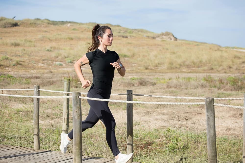 woman-in-black-activewear-running-on-a-boardwalk