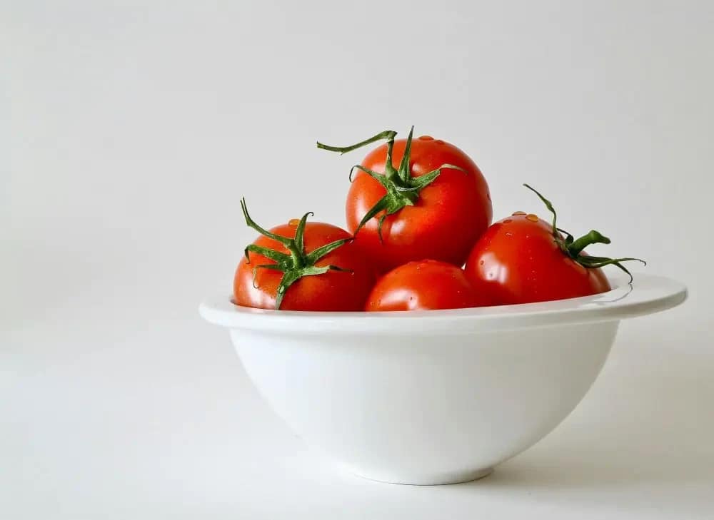 Red tomatoes in a small white bowl.