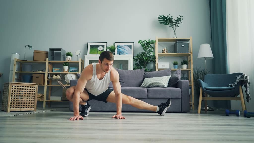 a man stretching in front of a couch-The Ultimate Guide to Getting Fit in 10-15 Minutes a Day