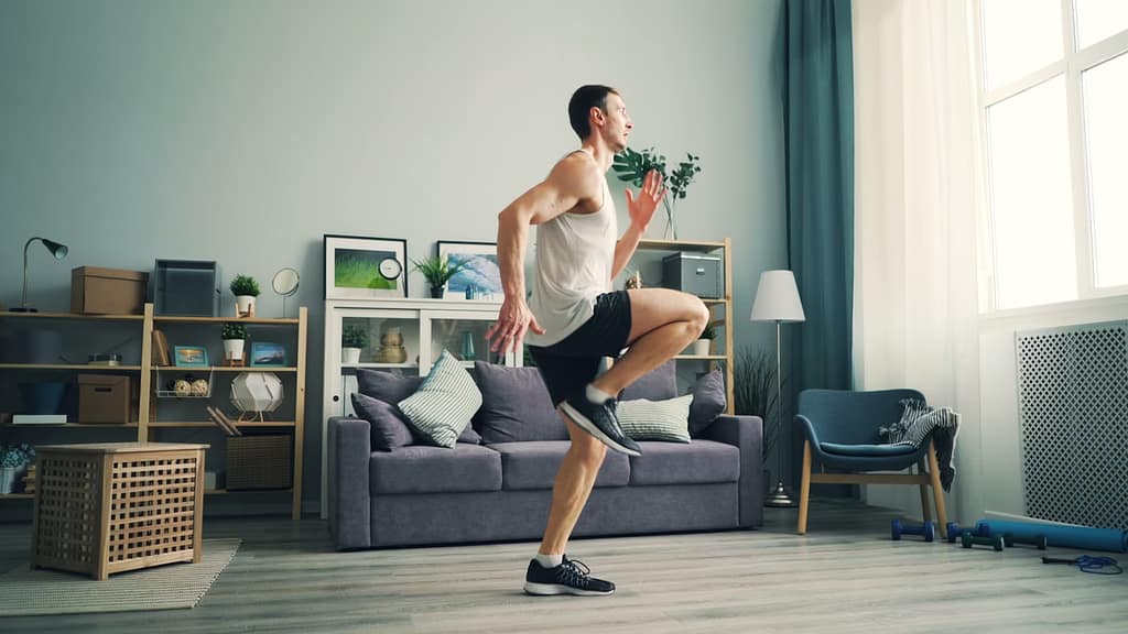 a man is jumping in a living room-The Ultimate Guide to Getting Fit in 10-15 Minutes a Day