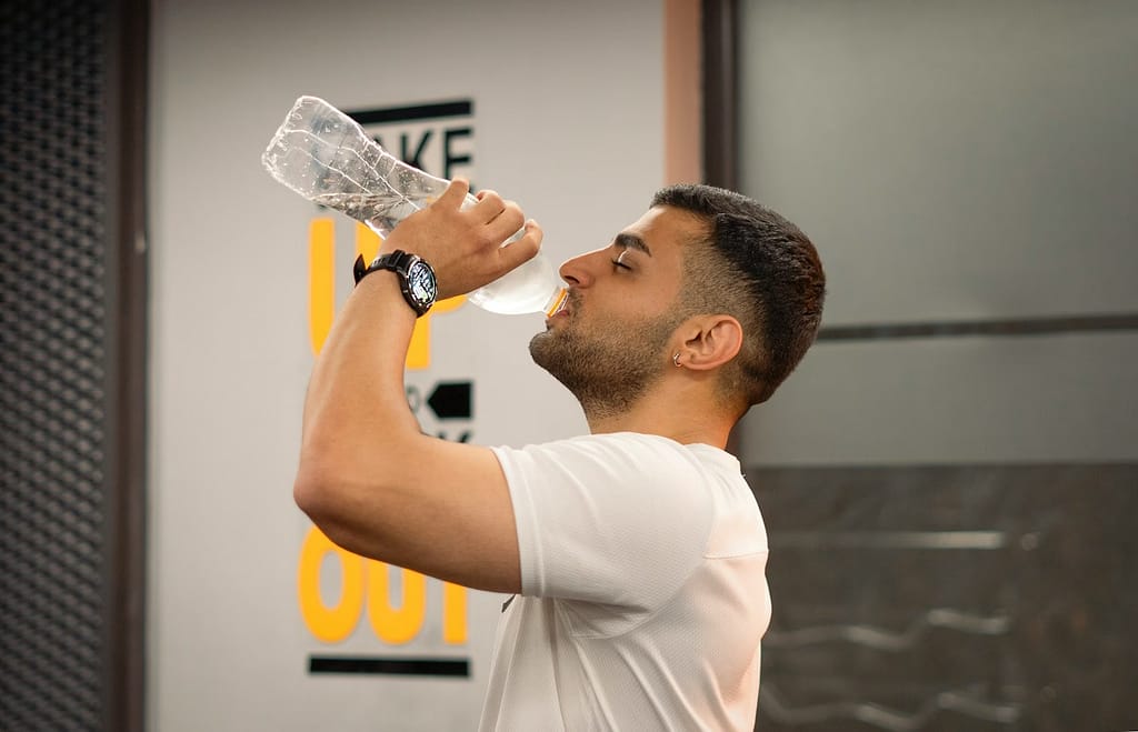 Man drinking water from bottle in gym-The Truth About Bottled Water