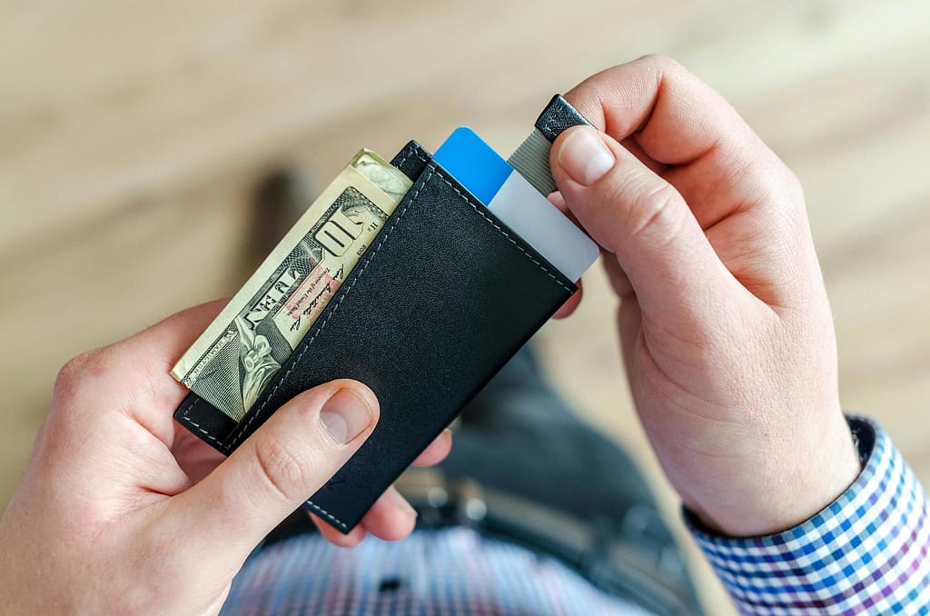 Someone holding a wallet with money in it-The Financial Sacrifice Teachers Make No One Sees