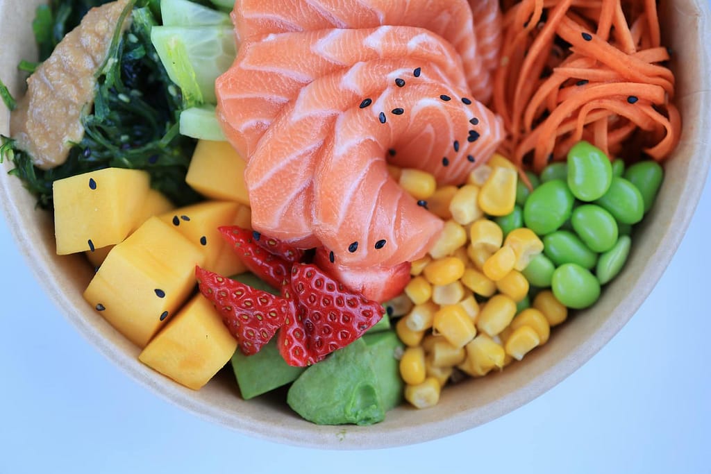 Colorful poke bowl featuring fresh salmon, vegetables, and fruits for a healthy meal. How to Optimize Metabolic Health Naturally