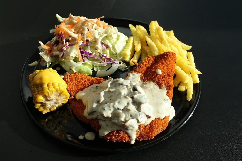 a plate of food that includes fries and sweet salad toppings-example of hidden calories in healthy food.