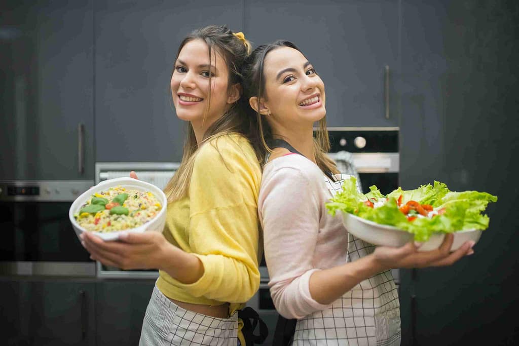 Two women holding bowls of salads-The Hidden Truth Behind “You Are What You Eat” Will Surprise You