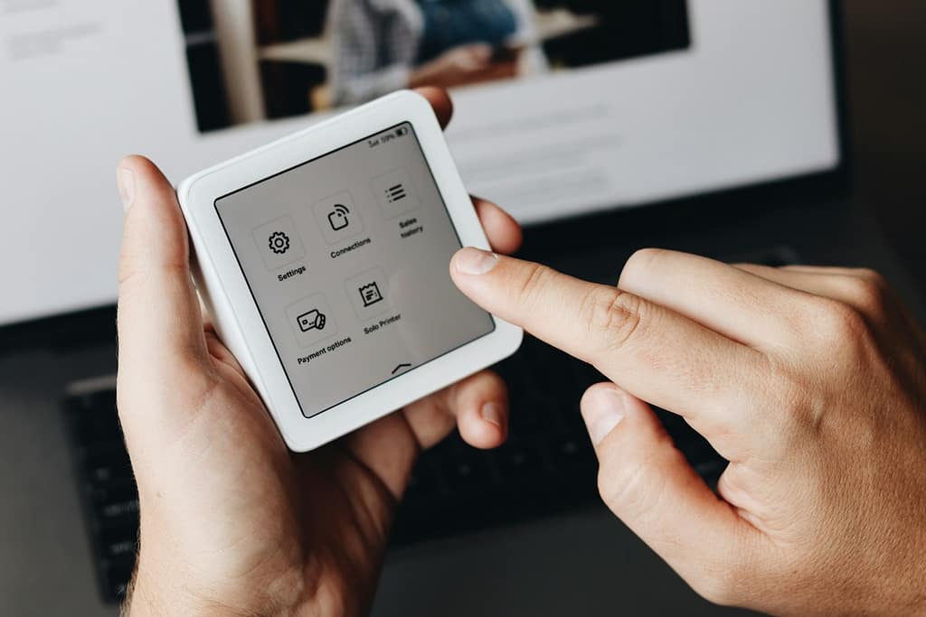 A person holding a tablet in front of a laptop-mental fitness apps and AI you should know about