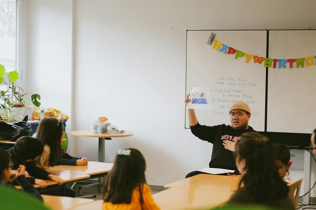 a teacher in front of a whiteboard in a classroom-The Emotional Labor of Teachers No One Sees