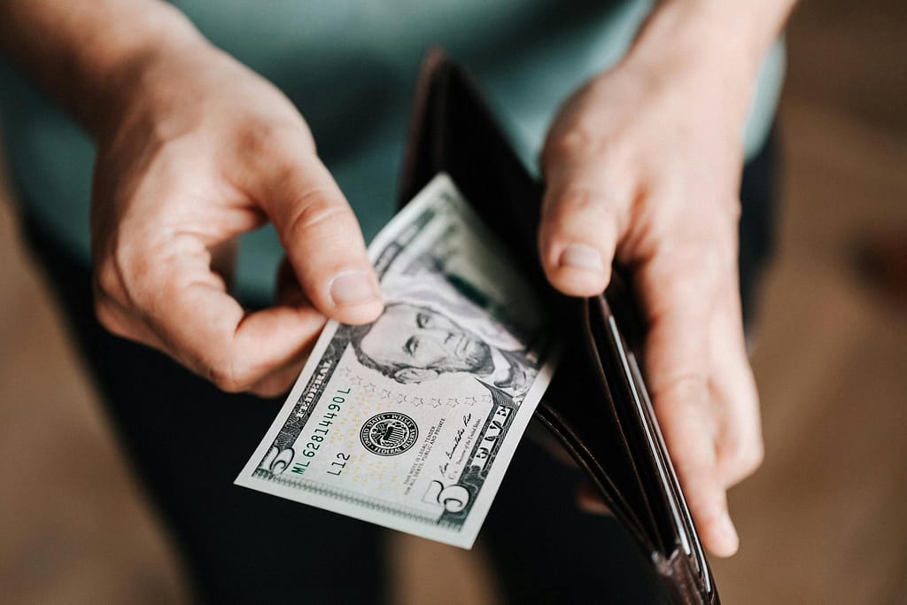 Someone taking money out of the wallet-The Financial Sacrifice Teachers Make No One Sees
