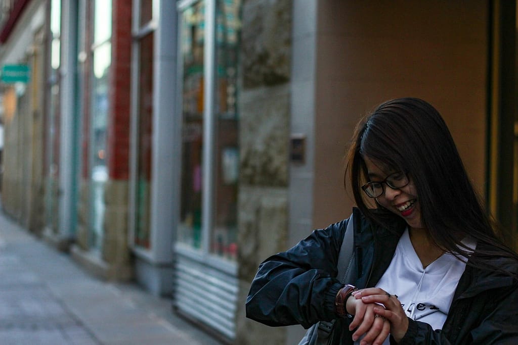 woman in black jacket looking at her watch-The Ultimate Guide to Getting Fit in 10-15 Minutes a Day