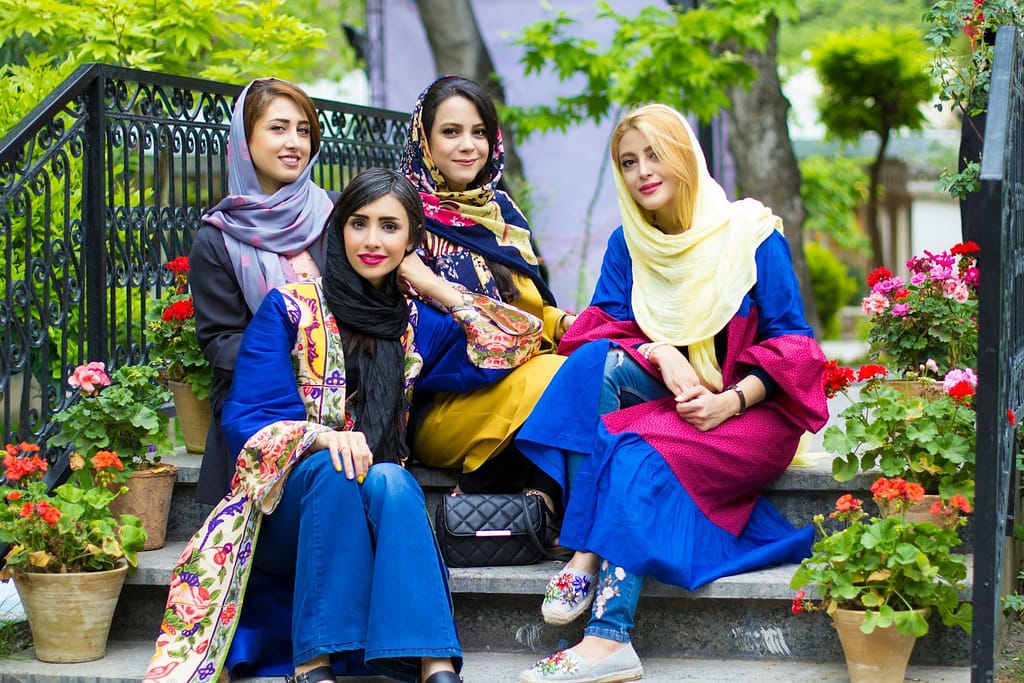 Women sitting on black metal bench