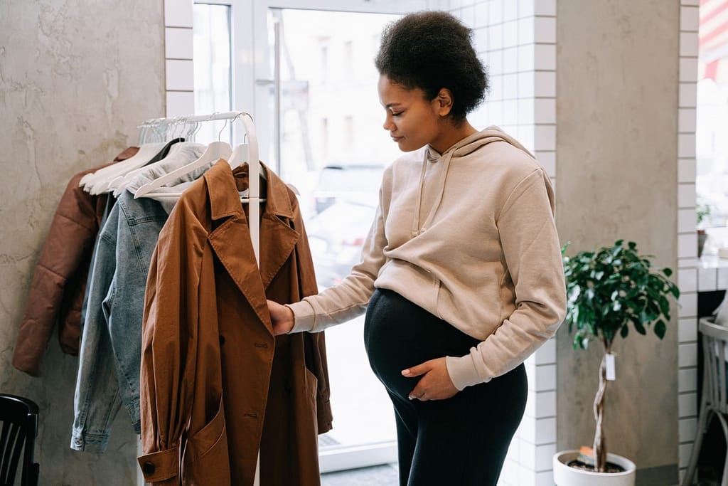 A pregnant woman in a casual hoodie browses jackets in an indoor store settingCan Trauma Be Passed Down Through Generations?