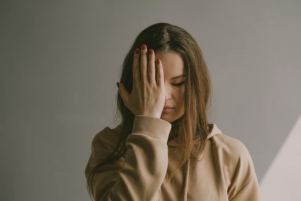 a woman covering her face with her hand