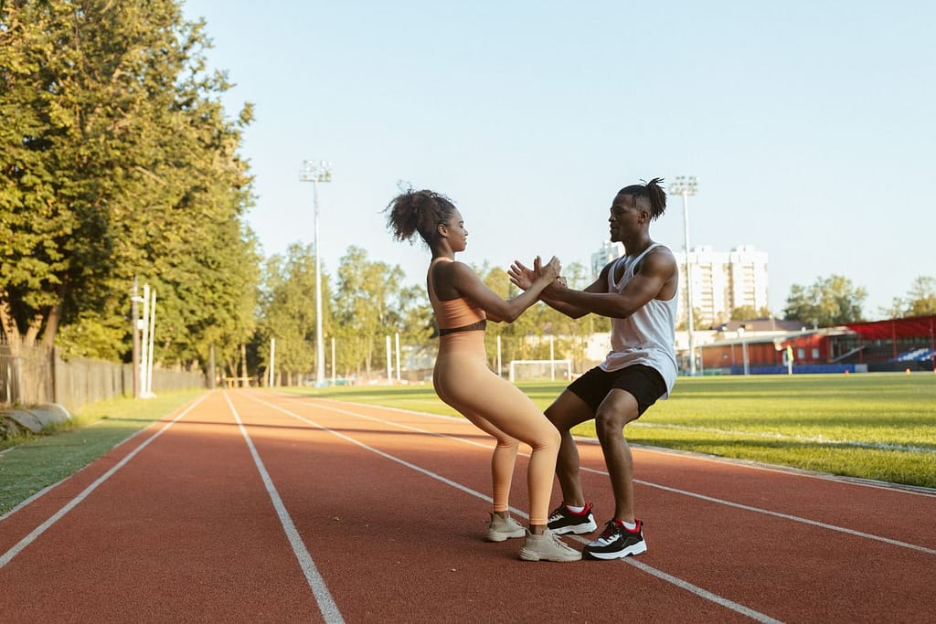 Two athletes exercising on an outdoor track, promoting fitness and teamwork.