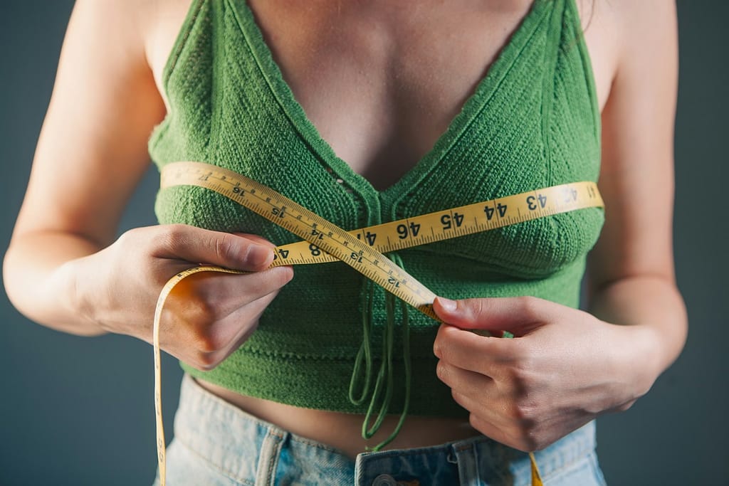 Woman measuring her bust with a tape measure-How to Lose Weight Without Going to the Gym.