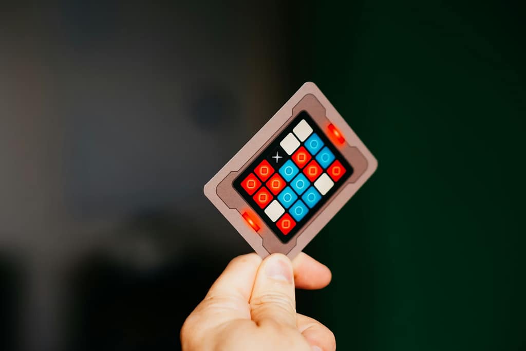 A hand holds a colorful puzzle card-Kwamzworld Memory Flip Challenge