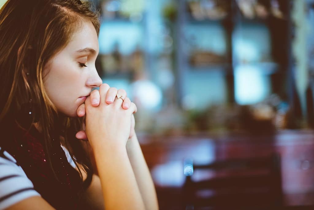 A woman praying-The Amazing Effects of Prayer and Your Body’s Well-being