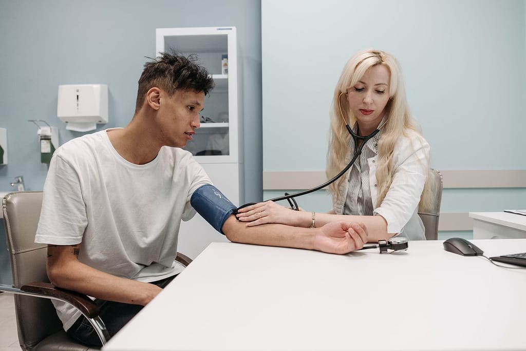 A doctor measures a patient's blood pressure in a clinic setting, focusing on healthcare and wellness-Why Healthy People Still Have High Blood Pressure