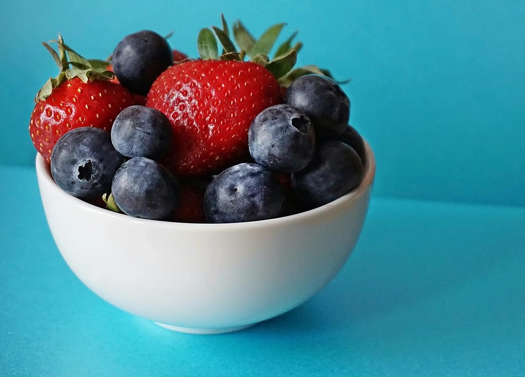 Blueberries and strawberries in a white bowl- Top 10 Scientifically Proven Cancer-Fighting Foods To Know About
