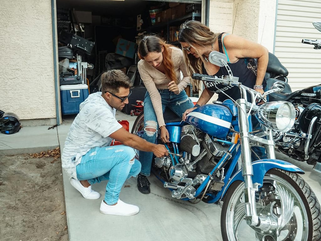 Family members enjoy bonding time while working on a blue motorcycle together in the garage. Hands-On Learning Is The Best Way to Learn New Skills Faster