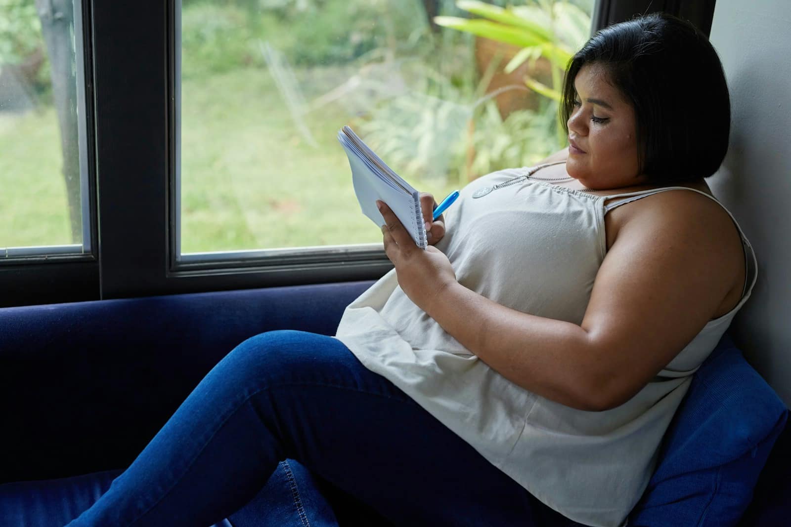 a woman sitting on a couch reading a book-Proven Ways to Crush Stress Belly Fat for Good