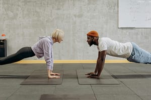 a man and a woman doing push-up exercise