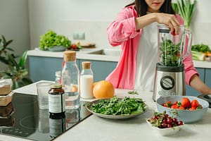 a woman using a blender, one of the top 10 health and fitness gadgets