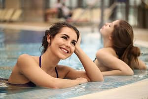 Two smiling women enjoying a relaxing day at the pool, embracing leisure and happiness-The Best Cardio Workouts for Burning Fat Fast