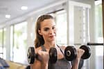 Woman in Gray Tank Top Holding Two Black Dumbbells-How to Use the 3-3-3 Rule for Insane Gym Focus and Growth